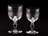 two empty wine glasses sitting next to each other on a table