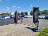 cars parked in a parking lot with a black umbrella on top of it