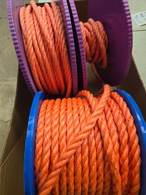 une corde orange dans une boîte, surmontée de bobines violettes
