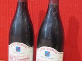 deux bouteilles de vin posées sur une table l'une à côté de l'autre