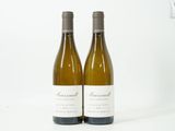 deux bouteilles de vin blanc posées l'une à côté de l'autre sur une surface blanche