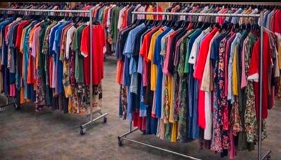 a lot of clothes hanging on a rack in a store