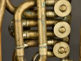a close up of a brass colored instrument with pipes and valves
