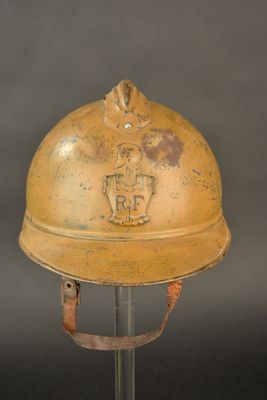 an old yellow helmet with a horse on it sitting on a metal stand