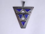 a silver and blue triangle shaped pendant on a white surface