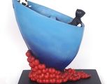 a sculpture of a bowl with red berries on a black base
