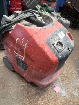 a red and black suitcase sitting on the floor in a garage