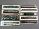 six trains miniatures dans des boîtes en plastique, posés sur une table