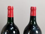 two bottles of wine sitting next to each other on a table