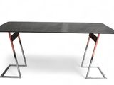 une image représentant une table avec un plateau noir et des pieds argentés