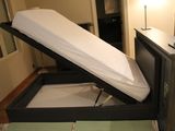 un lit avec un matelas posé dessus, dans une chambre