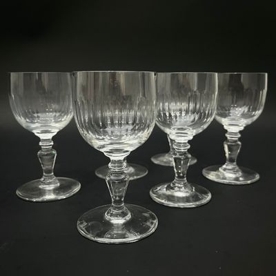 quatre verres à vin vides sont alignés sur une surface noire