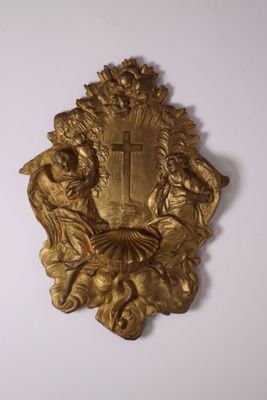 a gold plaque with a cross on it on the wall