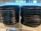 de nombreuses assiettes noires empilées les unes sur les autres sur une étagère