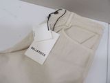 the label on a pair of beige pants is attached to a tag