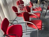 many red chairs sitting in a row in a room