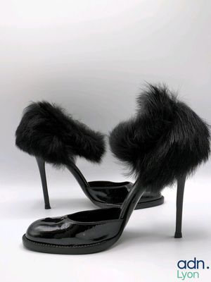 black high heeled shoes with fur on the toes on a white background