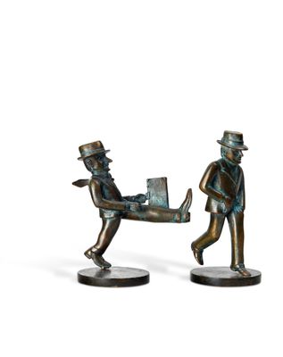 bronze figurines of a man and a woman carrying a suitcase