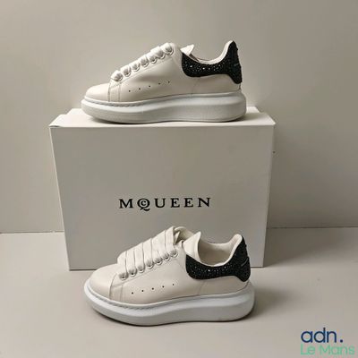 une paire de baskets blanches ornées de détails noirs et blancs