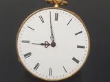 a gold clock with roman numerals on the face