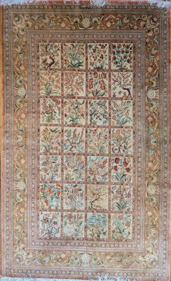 a large antique persian rug with a floral design on a beige ground