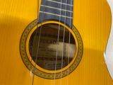 a close up of a yellow guitar with a label on it