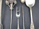 several spoons, forks, and spoon rest on a black surface