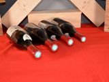 several bottles of wine are lined up on a red table cloth