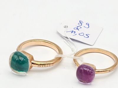 une paire de bagues en or ornées de pierres vertes et violettes, avec une étiquette de prix