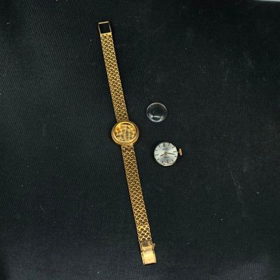 un gros plan d'une montre et une montre posée sur une surface noire