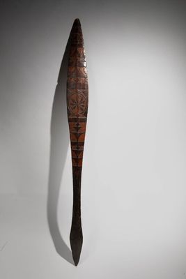 an old wooden spoon with a long handle on a white surface