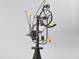 an image of a sculpture of a spinning machine with yellow balls on it