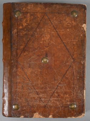 an old leather book with rivets and rivets sitting on a table