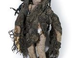 a dirty doll that is sitting on a white surface
