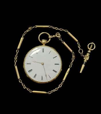 un gros plan d'une montre de poche en or entourée d'une chaîne