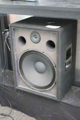 a speaker sitting on top of a table next to a laptop