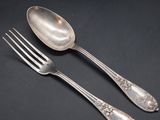 two spoons and a fork on a black surface