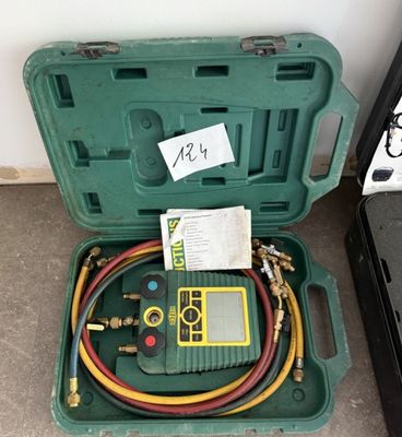 une mallette verte contenant deux tuyaux et un compteur