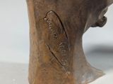 a bronze statue of a man ' s head with a bird on it