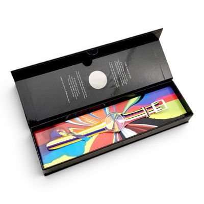 une boîte noire contenant un crayon, posée sur une surface blanche