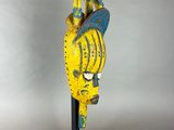 a yellow and blue statue of a bird on a black stand