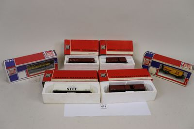 six boîtes contenant des trains miniatures, posées sur une table