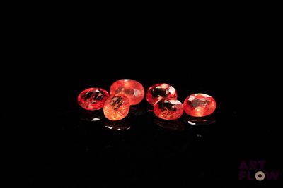 a close up of a pair of red diamonds on a black surface
