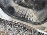 a dirty door of a car that has been left on the ground