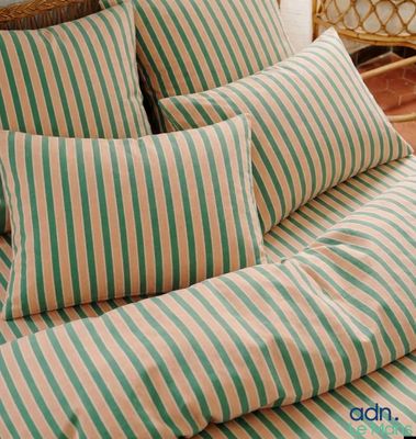 un lit recouvert d'une couette rayée verte et blanche