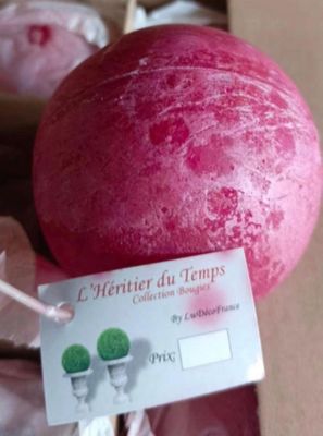 une balle rouge à laquelle est attachée une étiquette, posée sur une table