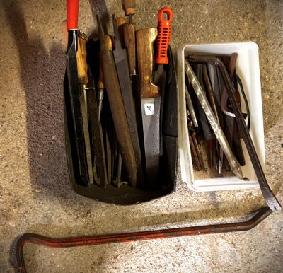 many different tools in a container on the floor