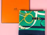 a close up of a green and blue scarf next to an orange box