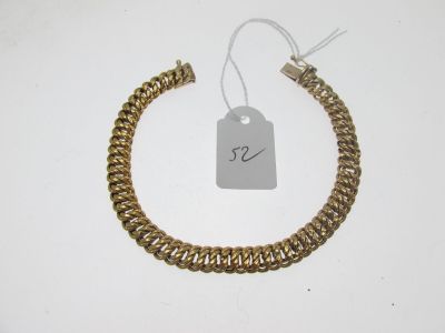 gros plan d'un bracelet en or portant une étiquette de prix