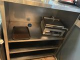 a metal shelf with two pans and a toaster on it